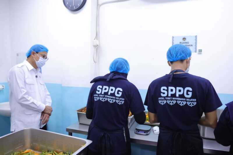 Taruna Ikrar menyimak penjelasan petugas dapur di fasilitas SPPG, memastikan semua langkah pengolahan makanan berjalan sesuai standar. (Foto: BPOM RI)